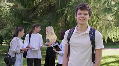 Male student 16, 17 years old with backpack, in school park
