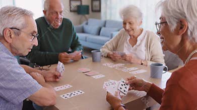 Senior friends playing cards together at nursing home