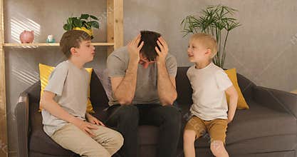 Father put his hands around his head, the children are fighting and arguing. Parent is tired of noisy children. Family