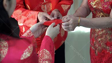 Daughter giving red envelope to parents during Chinese new year day wish for wealth and prospect