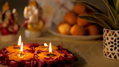 Beautifully decorated puja area with wax Diyas lighted to worship Laxmi-Ganesh