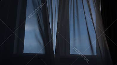 Strong wind blowing in open window and swaying thin curtain
