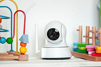 IP camera on the shelf with toys, serving as baby monitor