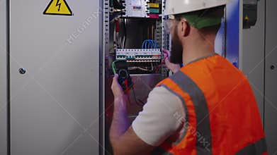 repair of industrial electrical panel in plant, electrician is checking circuit breakers