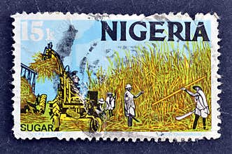Cancelled postage stamp printed by Nigeria, that shows Sugar harvest production