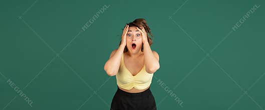Young Caucasian beautiful woman in casual clothes  on green background.