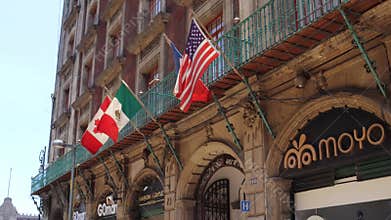 Flags of different countries waving on the facade of a hotel