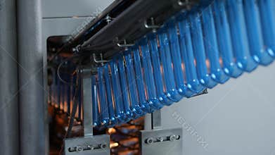 The blue preforms are sent to the blow molding machine. Production of plastic bottles at the mineral water bottling plant
