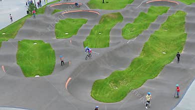 Children ride bicycles, scooters in skatepark