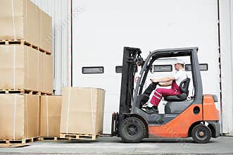 Worker driver at warehouse forklift loader works