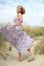 Active older woman dancing at the beach