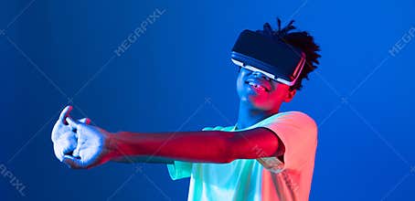 African sport player wearing VR stretching arm neon light wall. Contrivance.