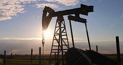 Energy from fossil fuels. Close-up of an industrial oil pump pumping oil in the countryside.