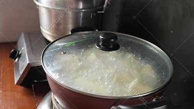 Boiling cassava in hot pot on stove