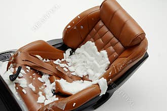 An old damaged car seat reveals the wear and tear of time and usage. The rich brown color stands in contrast to the