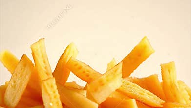 Growing pile of french fries accumulates on a white background, popular fast food snack.