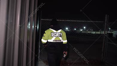 Security guard patrolling commercial site at night as a fire watch