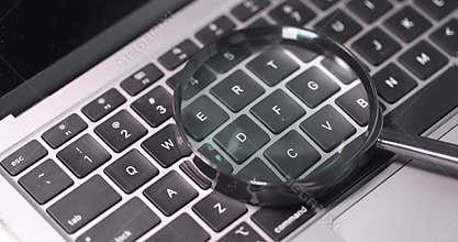 Magnifying glass lies on computer keyboard slow motion 4k movie