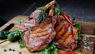 Lamb pork chops grilled with salad on wooden cutting board rotate. Loin on ribs