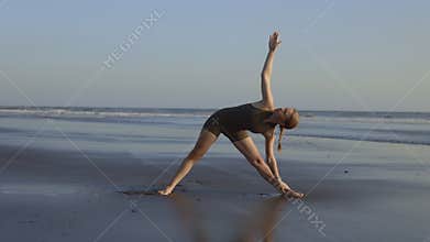 Beautiful Blonde Woman in Sportswear Exercising Outside on the Seashore. Woman Training Outdoors on the Beach. Coach