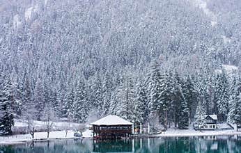 the emerald lake under the snowflakes in early winter