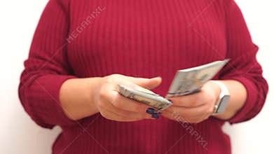 Female hands, dollar counting. Depicting finance and accounting themes. A person is counting 100 dollar bills in hand