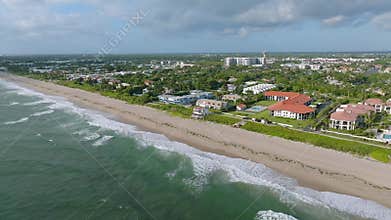 Aerial view of picturesque West Palm Beach, Florida with residential area and long sandy shoreline on background. Blue