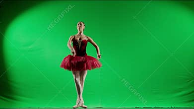 Portrait of female on chroma key green screen background. Beautiful ballerina in red tutu and black body dancing
