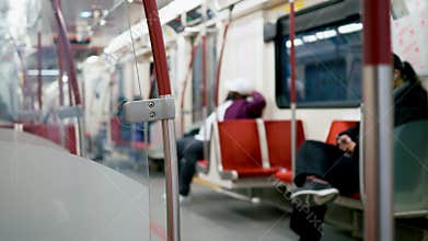 Defocused shot of passengers riding at night subway car. Dynamic video of calm passengers on red comfortable carriage