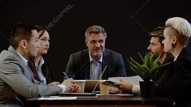 Business partnership communicating with investors boardroom. Five coworkers analyzing documents. Executive director