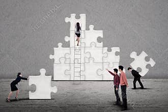 Business team build puzzle together