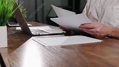 Hands with business papers, abstract documents at office wood table, desk with laptop.