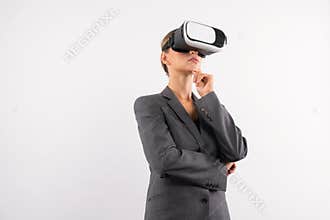 Smart businesswoman thinking about plan while wearing VR glasses. Contraption.