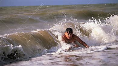 Two boys dive into a foaming wave. Live a healthy life. Be H3althy