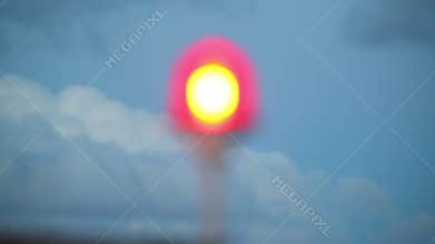 Red beacon on tall building at background of blue