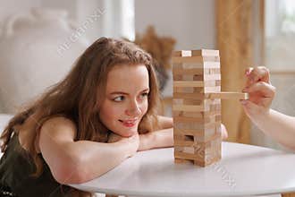 two women playing Jenga board game at home, excitement and relaxation, mind development concept,