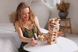 two women playing Jenga board game at home, excitement and relaxation, mind development concept,