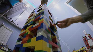 Young boy builds toy tower on floor in room.
