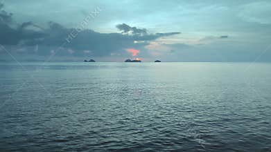 Drone voyage towards blushing dawn across sea, underlines nature splendor. Amidst clouds, it showcases endless beauty