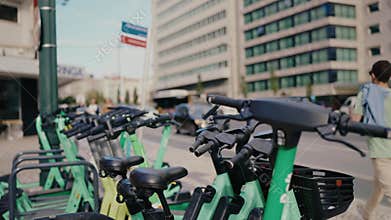 Green Electric Scooters Parked on Urban Street Near Modern Office Buildings