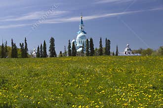 Valaam Monastery above a field of dandelions