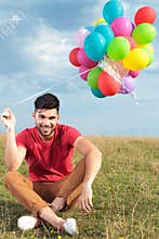 Casual man with a bunch of balloons in his hand