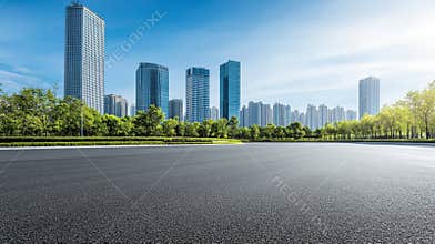 Image of a clean, empty road in front of a modern building in a city.