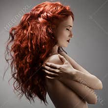 Beautiful woman with curly hairstyle against gray background