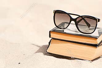 Books and sunglasses on a beach