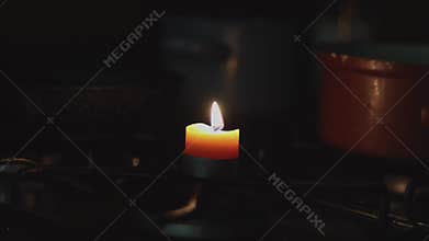 Burning candle on gas stove. Gas problems due to war in Ukraine