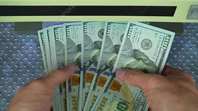 Man check bills on bill detector with UV light. Man hands took dollars into bill detector. Checking dollar banknotes in a UV light