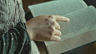 asian woman reading the Christian bible book on wooden table vintage room