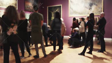 A group of people in a blur admires an exhibition of paintings in an art gallery. Museum Day and Cultural