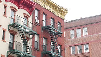 New York City building architecture, Manhattan. Residential house exterior. Red brick, fire escape.